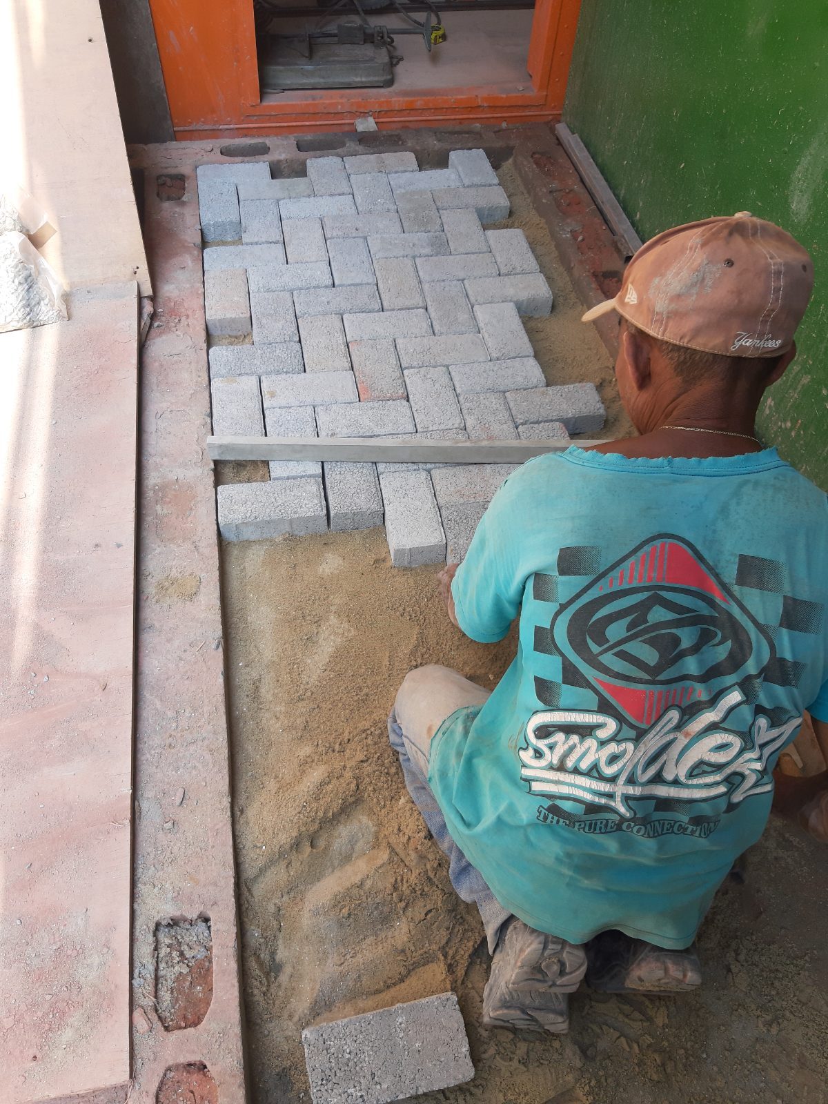 Worker laying paving stones for the courtyard floor
