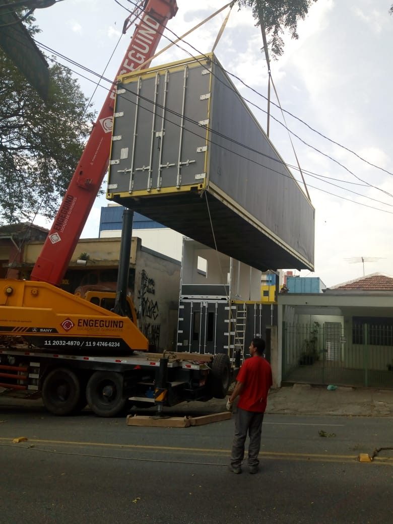 Crane stacking a steel container above another during the build