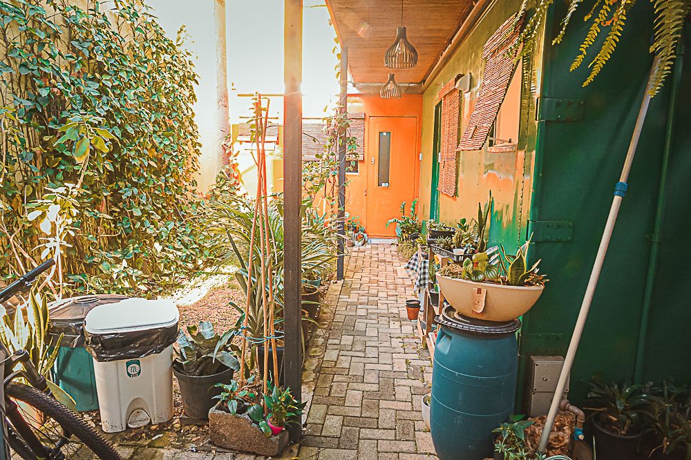 Corredor de jardim entre as casas container ao entardecer