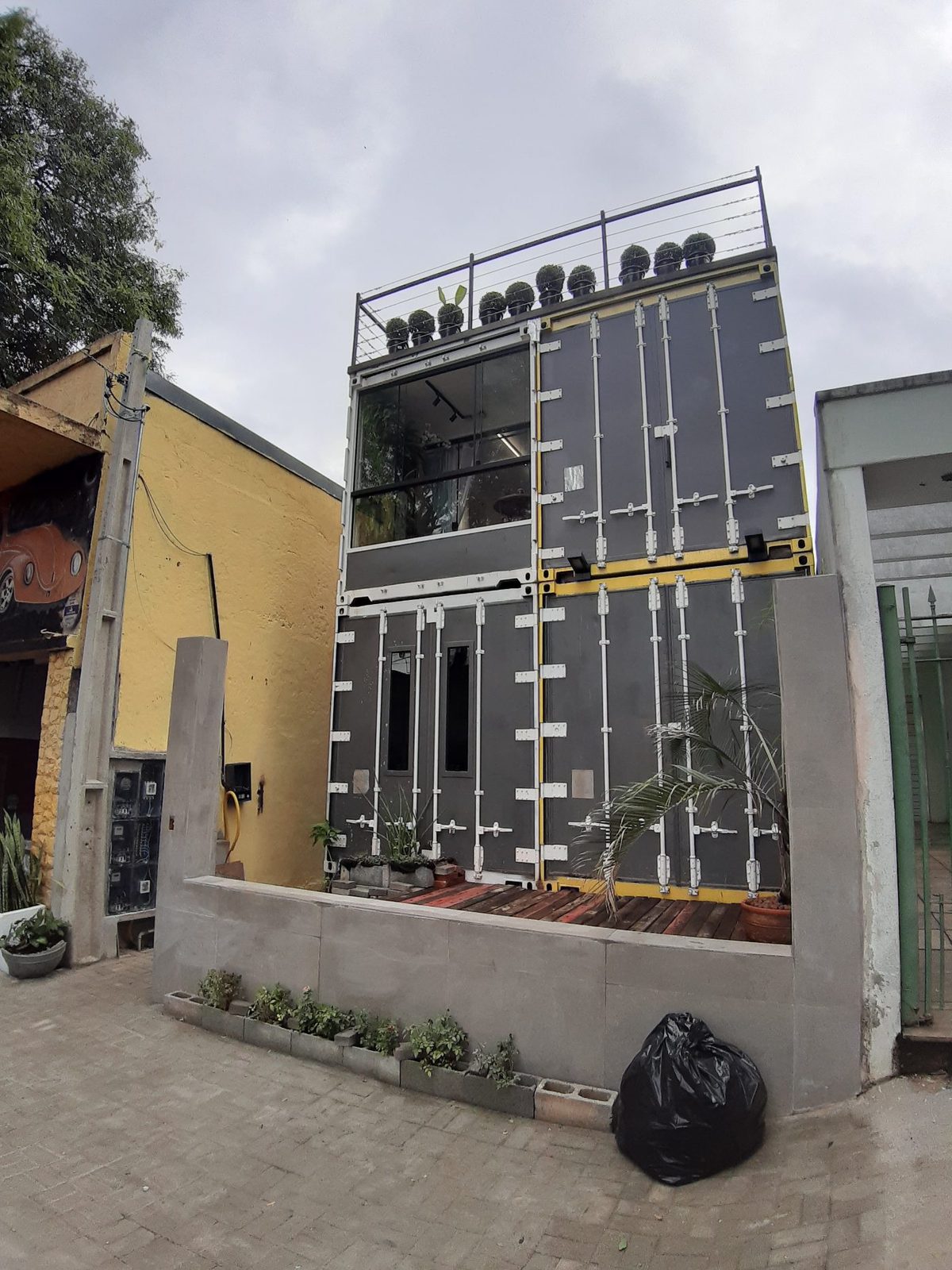Frente da casa — três containers empilhados formando um lar